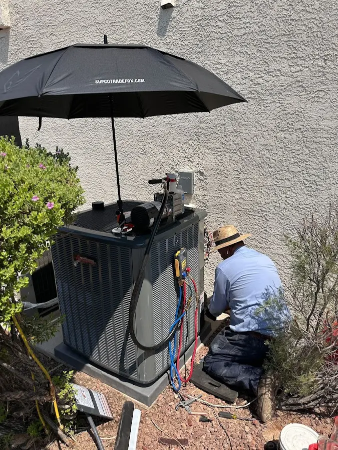 HVAC technician performing outdoor AC maintenance in Logan